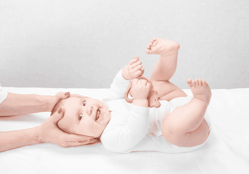 Baby lying on his front on the treatment table